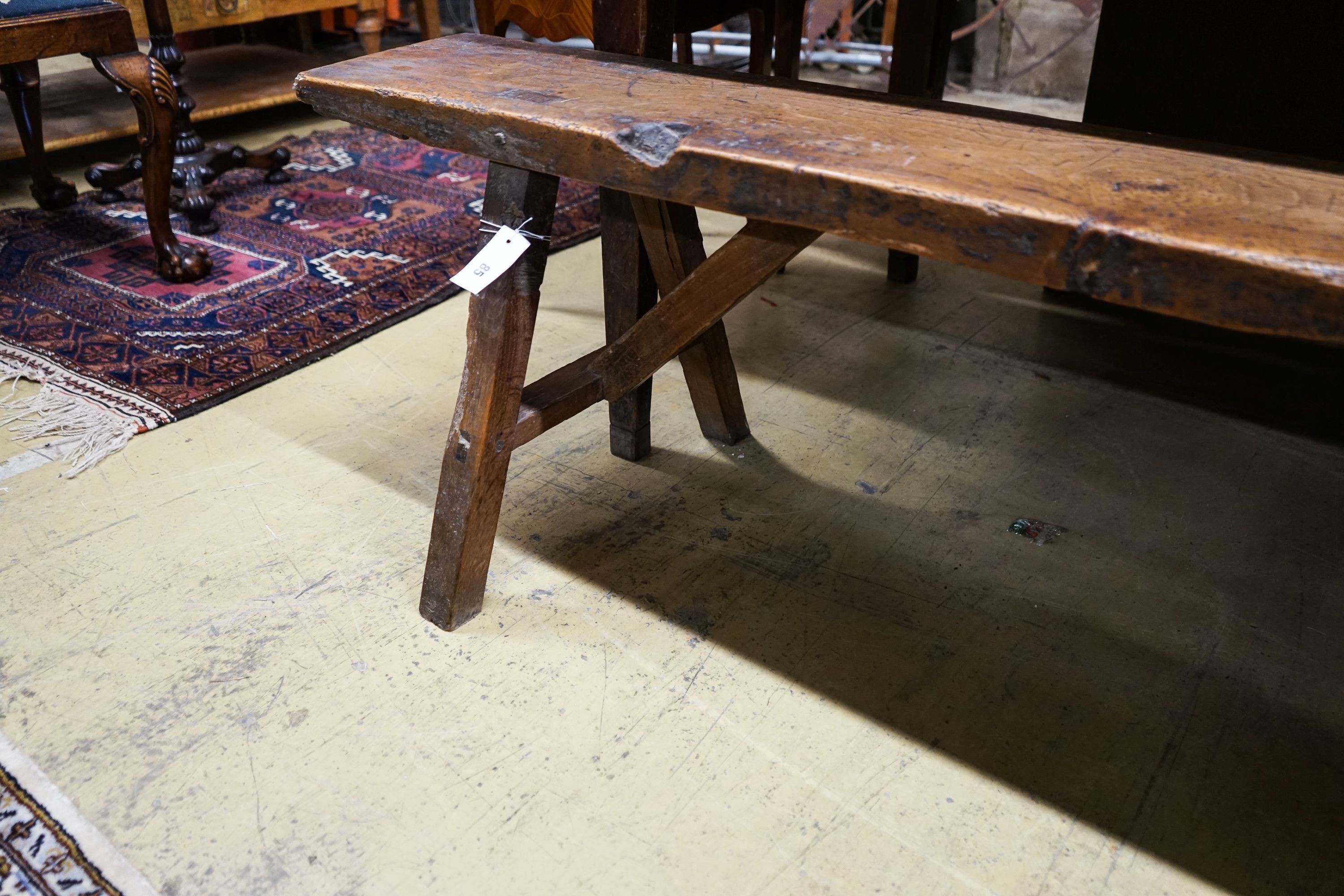 A 19th century French provincial cherry bench seat, length 242cm, depth 46cm, height 46cm